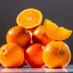 halbierte Orange auf mehreren Orangen liegend