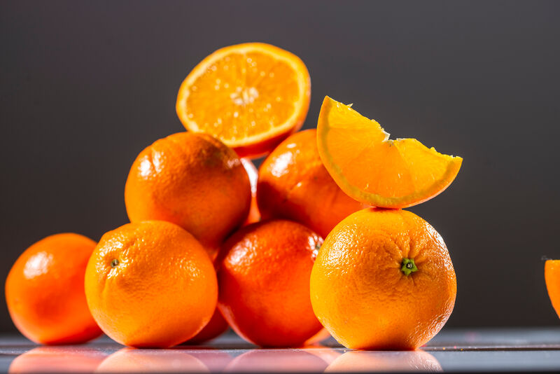 halbierte Orange auf mehreren Orangen liegend